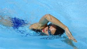 Die Frau schwimmt zügig durchs Wasser Die Frau schwimmt zügig durchs Wasser