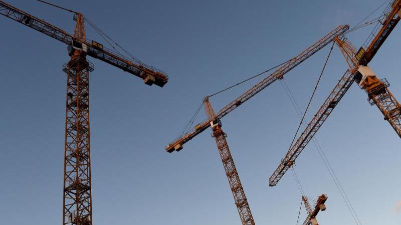 Stagnierende Baugenehmigungen und hohe Baukosten Baukräne stehen auf einer Baustelle