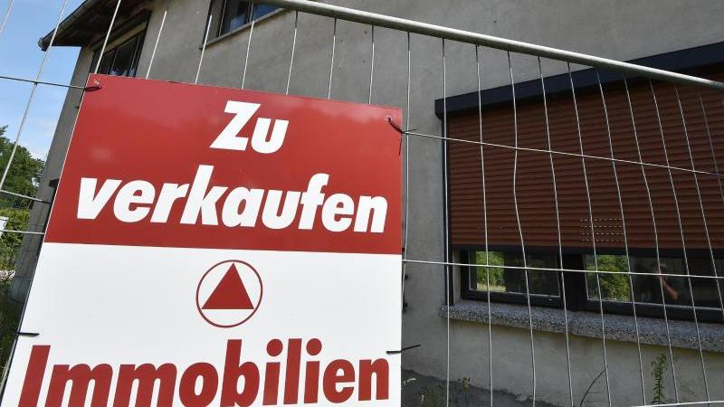 Experten sehen wachsende Kluft auf Immobilienmarkt Schild an Bauzaun vor Immobilie