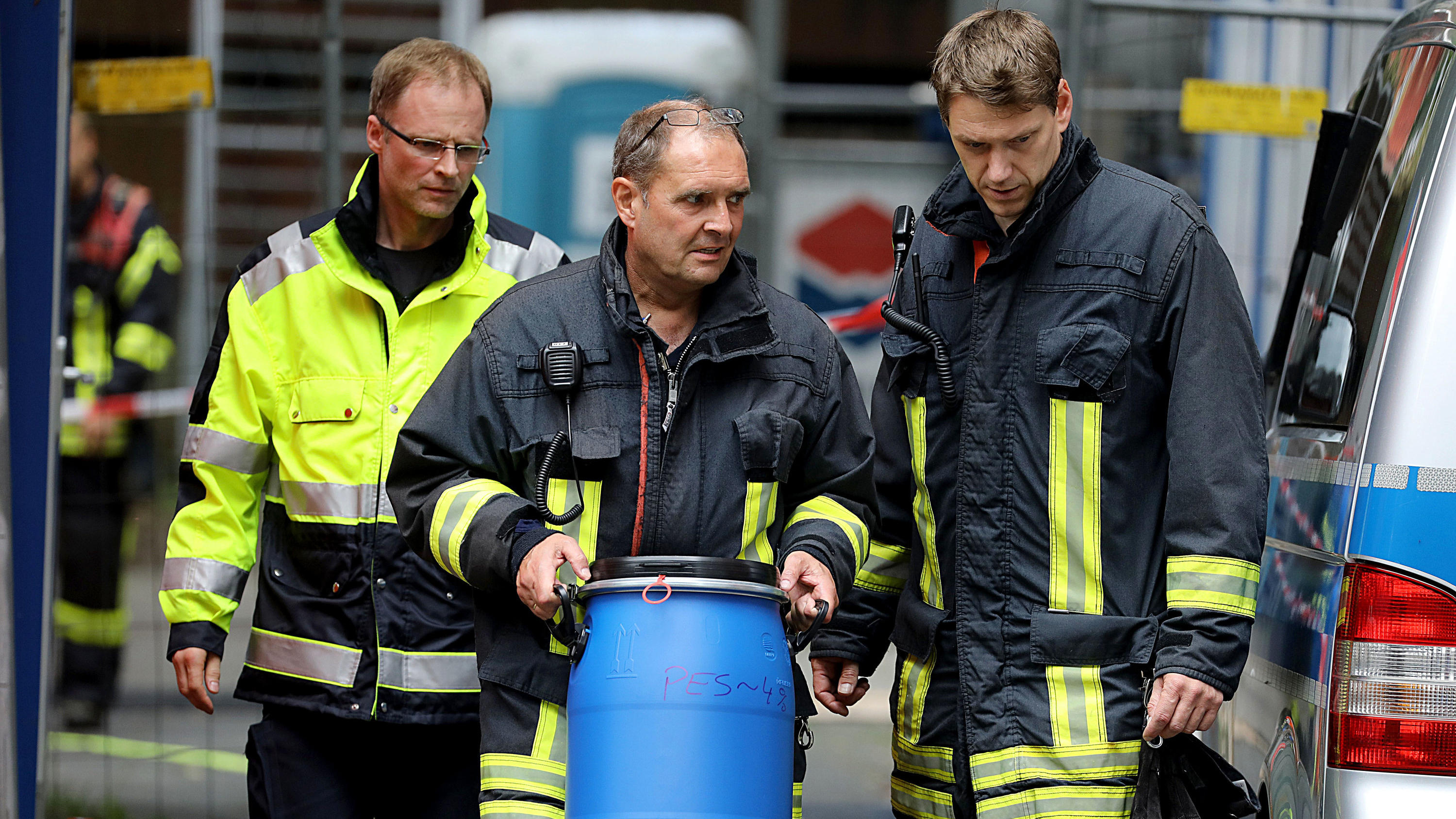 Nach Rizin-Fund in Köln: Jetzt spricht eine Nachbarin über das Gift-Ehepaar 15.06.2018, Nordrhein-Westfalen, Köln: Ein Feuerwehrmann trägt vor dem Wohnkomplex Osloerstr. 3 in Köln-Chorweiler eine Tonne raus. Nach dem Fund von hochgiftigem Rizin in einem Hochhaus in Köln will die Polizei am Freitagmorgen mehrere leerstehende