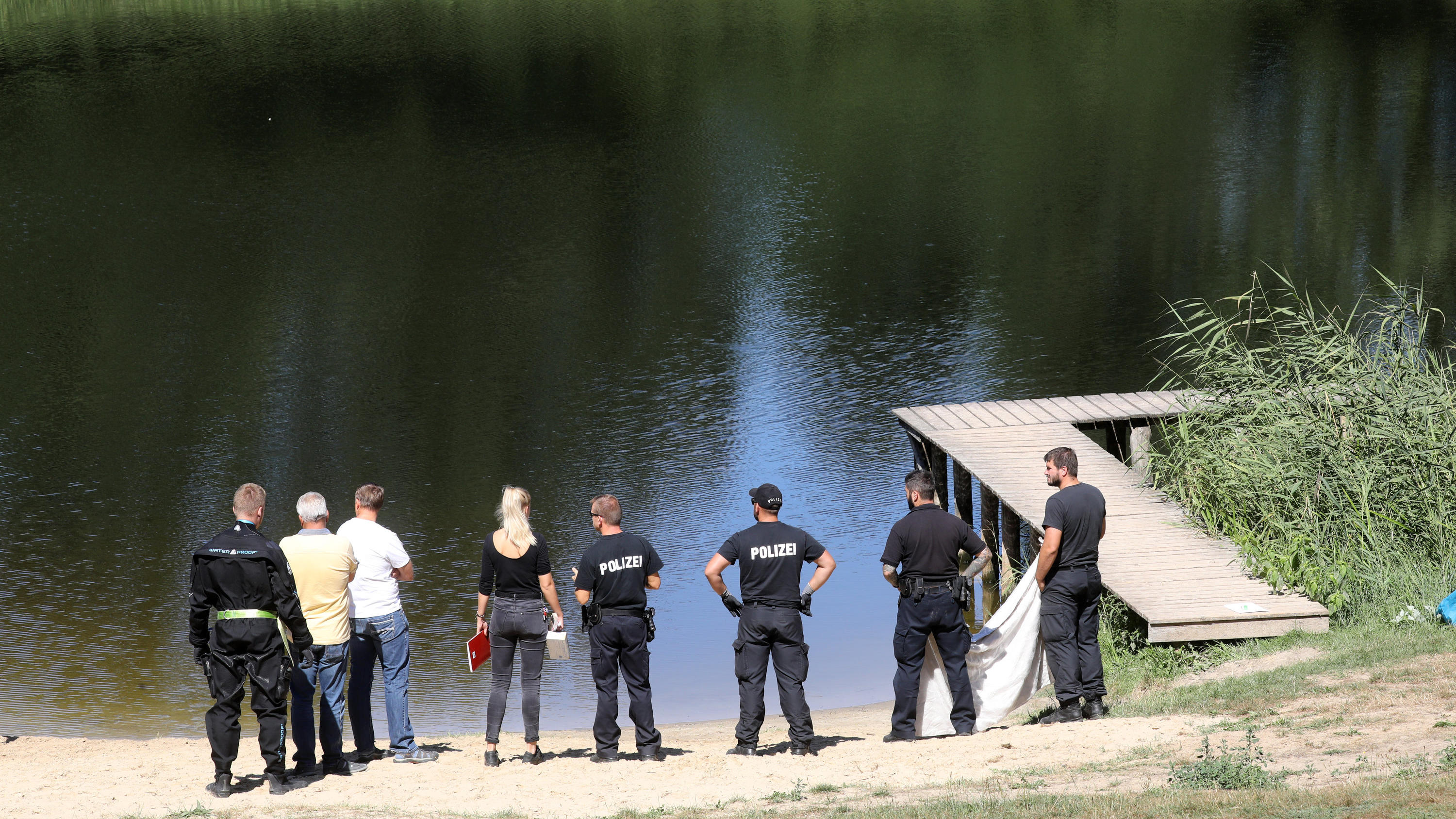 Immer mehr Badetote in Deutschland: DLRG warnt vor einem "Land der Nichtschwimmer" dpatopbilder - 06.08.2018, Mecklenburg-Vorpommern, Thelkow: Polizisten stehen am Ufer des Sees, in dem Taucher der Bereitschaftspolizei kurz zuvor den vermissten siebenjährigen Jungen leblos fanden. Der Junge war am Vorabend mit seiner Ferienlagergru
