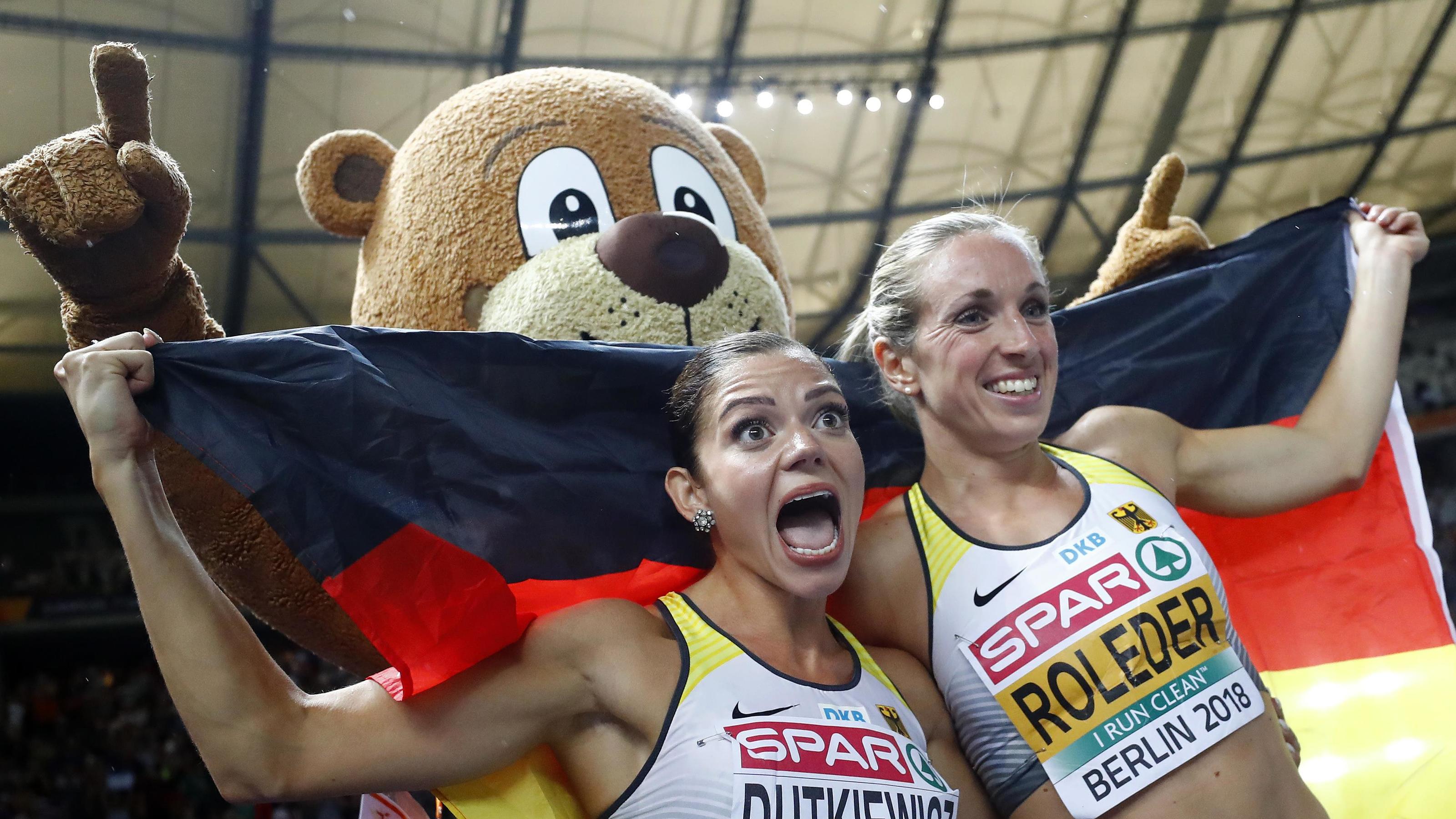Doppelschlag durch deutsches Hürden-Duo 2018 European Championships - Women's 100m Hurdles Final - Olympic Stadium, Berlin, Germany - August 9, 2018 - Second placed Pamela Dutkiewicz of Germany and third placed Cindy Roleder of Germany celebrate with games mascot Berlino. REUTERS/Kai Pfaff