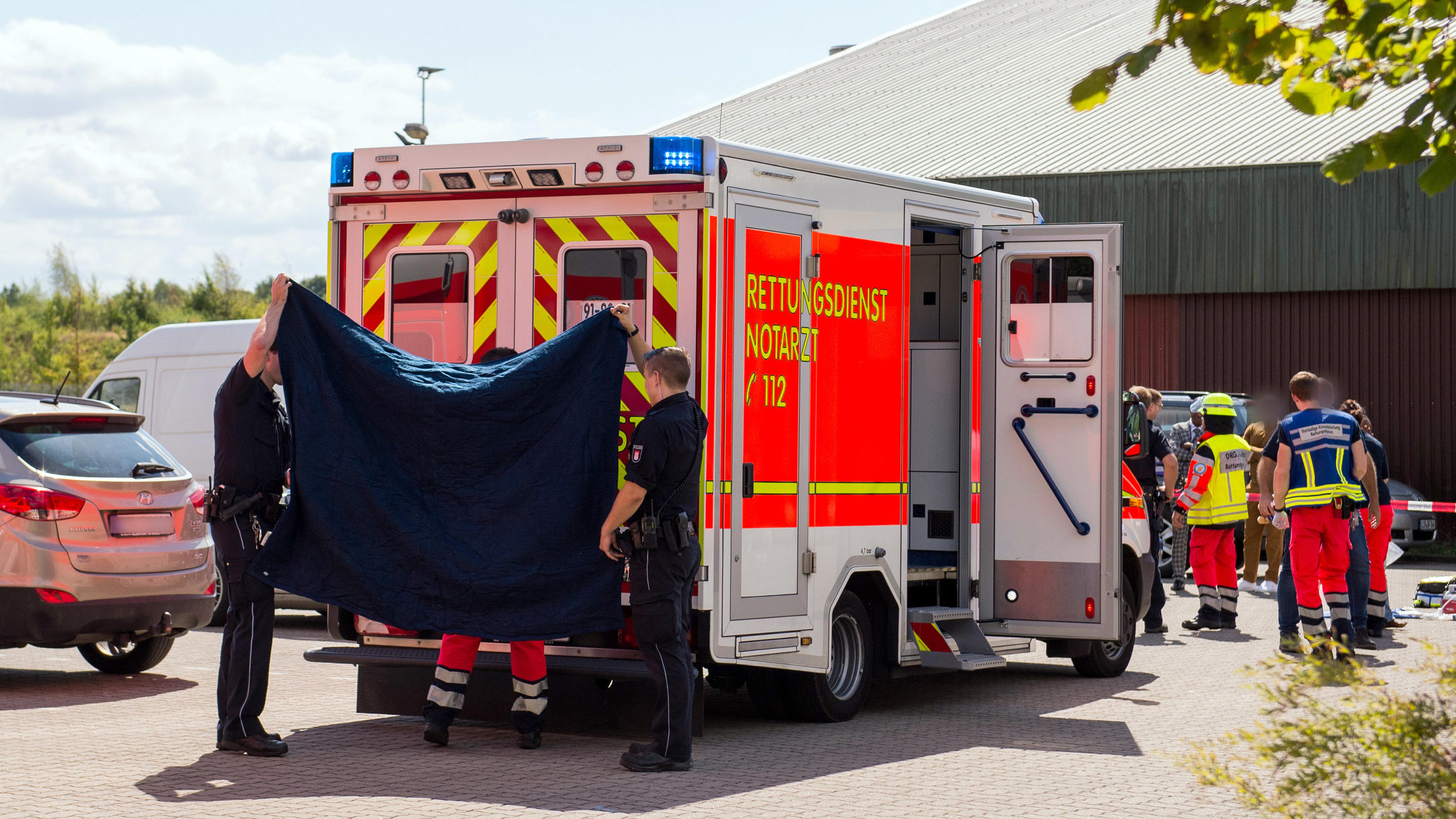 Drama in Glinde bei Hamburg: Jungen (5 und 6 Jahre) sterben nach Sturz in Wasserbecken 10.08.2018, Schleswig-Holstein, Glinde: Ein Rettungswagen steht auf dem Gelände eines Hotels. Zwei Kinder sind auf dem Gelände in ein Regenrückhaltebecken gefallen. Retter hätten sie aus dem Wasser geholt und reanimiert, sagte ein Polizeisprecher. Fo