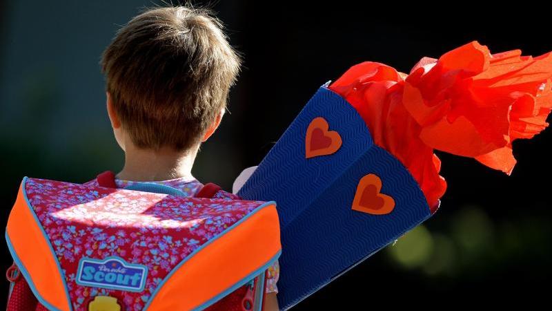 Rund 76 000 Kinder starten in die Schule Erstklässlerin trägt eine Schultüte