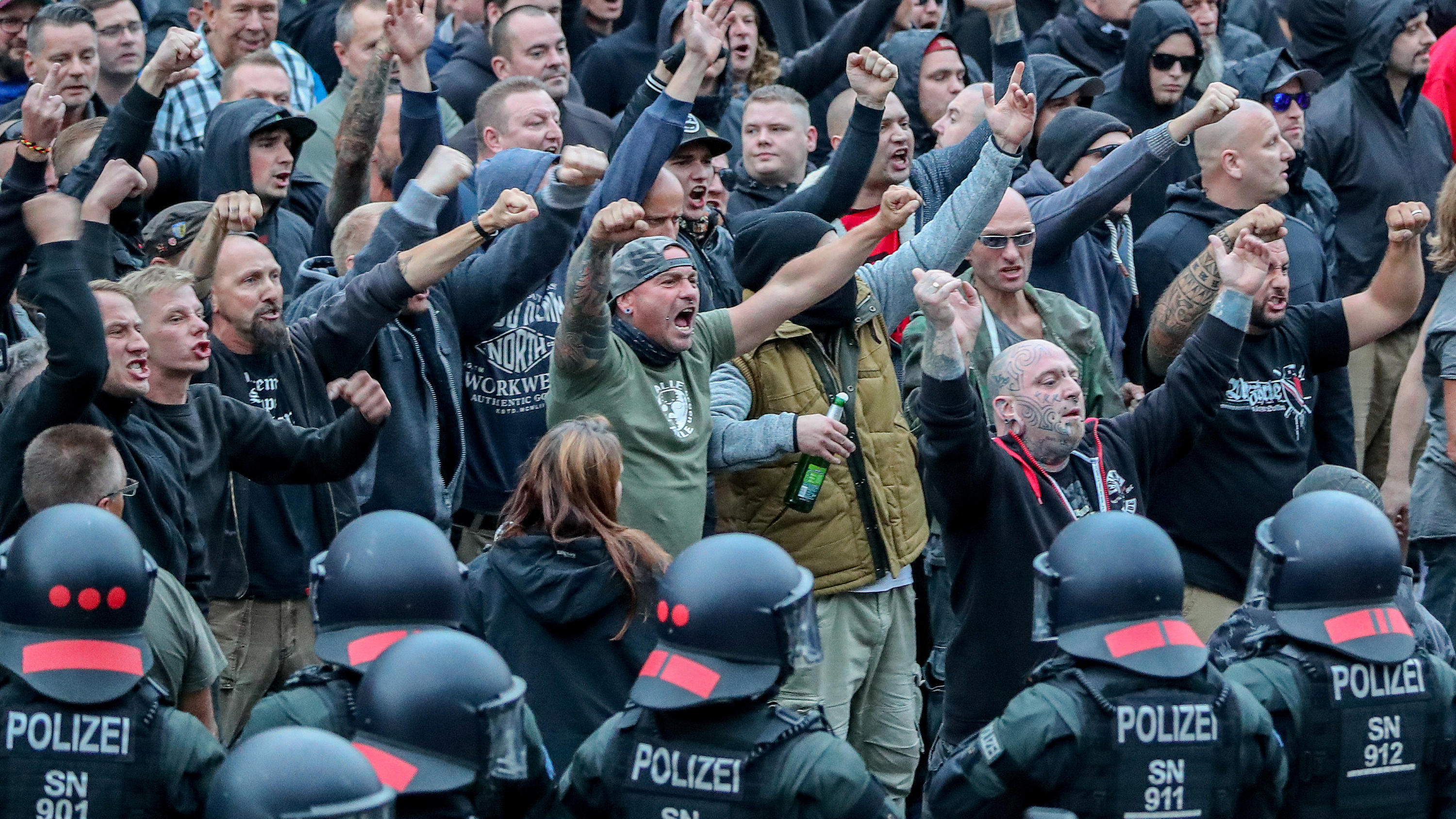 Verfassungsschutz-Chef Maaßen rudert zurück: Keine Zweifel an Echtheit des Chemnitz-Videos ARCHIV - 27.08.2018, Sachsen, Chemnitz: Demonstranten aus der rechten Szene gestikulieren und drohen Gegendemonstranten Gewalt an. Nach einem Streit war in der Innenstadt von Chemnitz ein Mann erstochen worden. Die Tat war Anlass für spontane Demonst