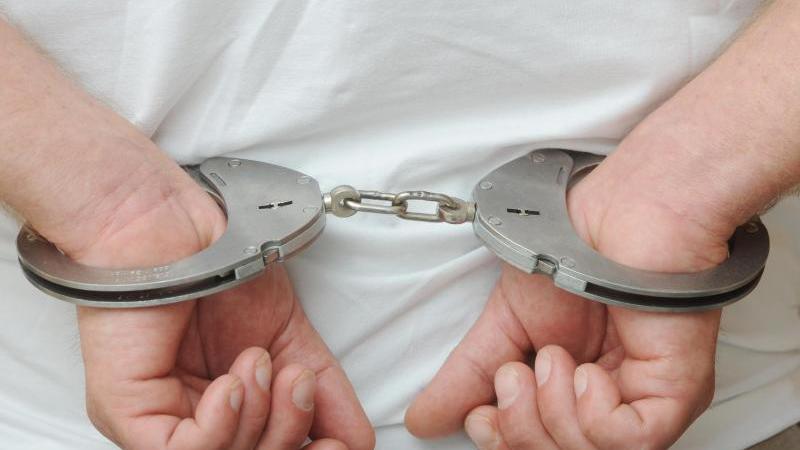 Haartrockner in Badewanne: Sohn soll Mutter getötet haben Ein Mann in Handschellen
