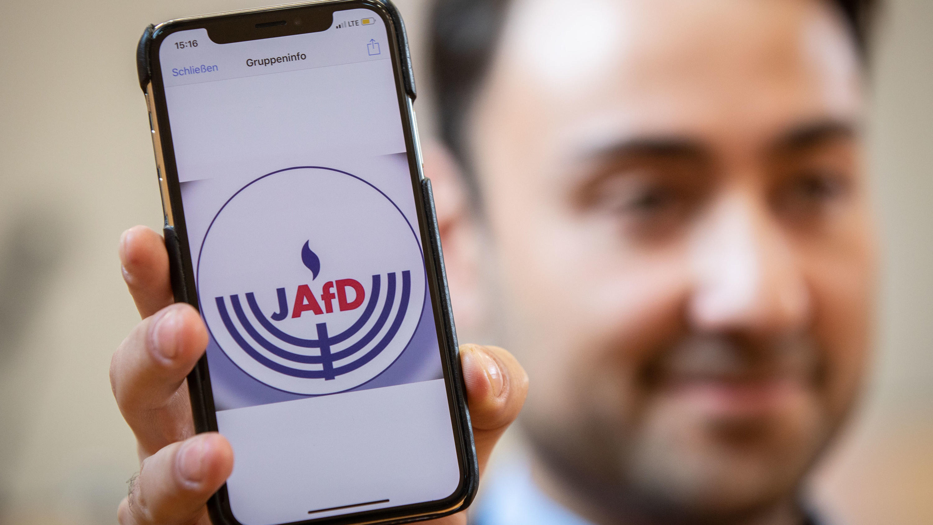 Gründung der JAfD in Wiesbaden: AfD möchte ihre "wertkonservativen" Ideen in jüdische Gesellschaft bringen 07.10.2018, Hessen, Wiesbaden: Beisitzer Leon Hakobian zeigt im Bürgerhaus im Stadtteil Erbenheim auf seinem Handy den vorläufigen Entwurf eines Logos der jüdischen Bundesvereinigung innerhalb der AfD, die wenig später gegründet werden sollte. Foto: