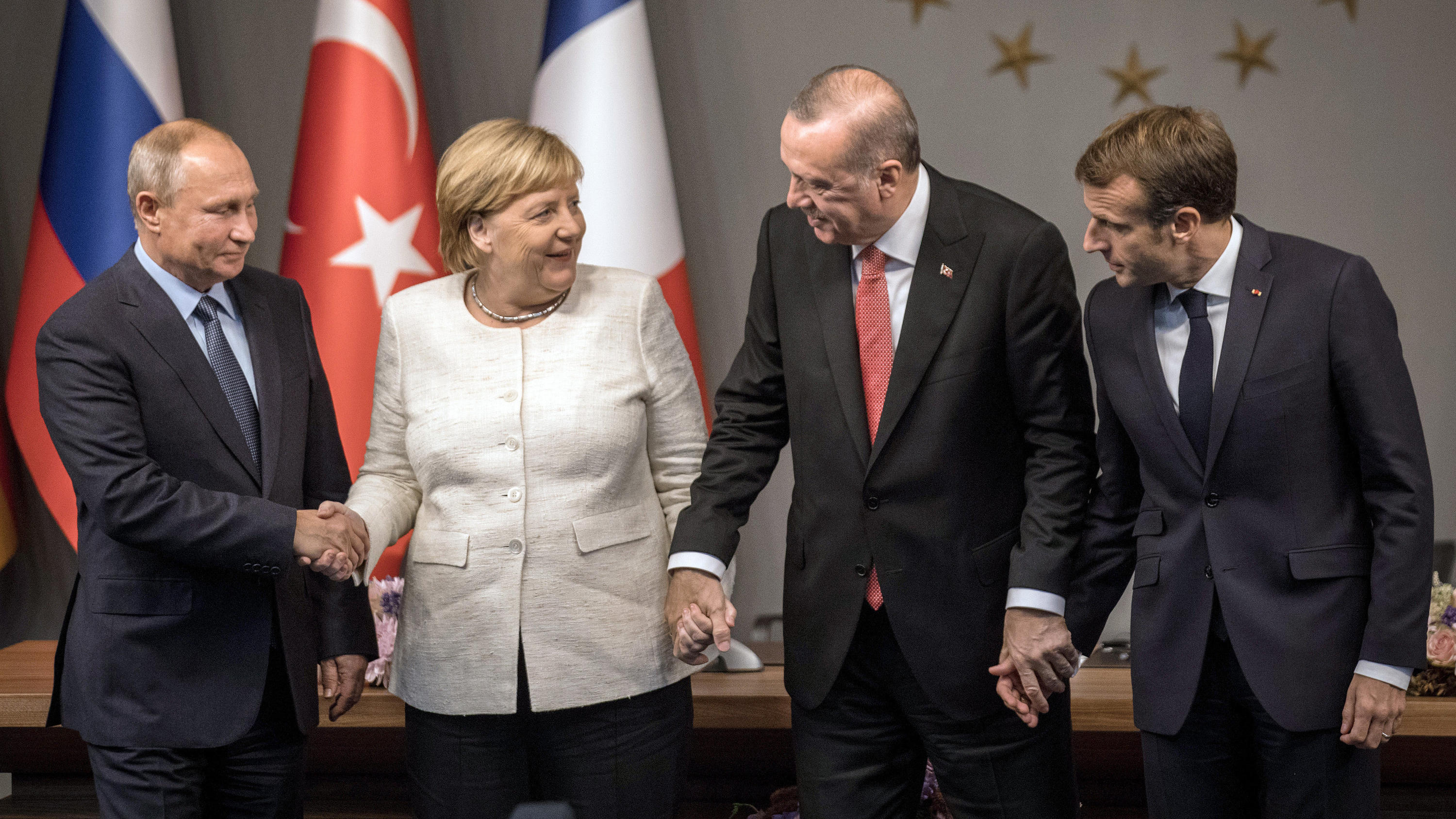 Syrien-Gipfel: Erdogan, Merkel, Macron und Putin planen Neustart des Friedensprozesses 27.10.2018, Türkei, Istanbul: Wladimir Putin (l-r), Bundeskanzlerin Angela Merkel (CDU), Recep Tayyip Erdogan, Staatspräsident der Türkei, und Emmanuel Macron, Präsident von Frankreich, reichen sich bei einer Pressekonferenz nach dem Gipfeltreffen di