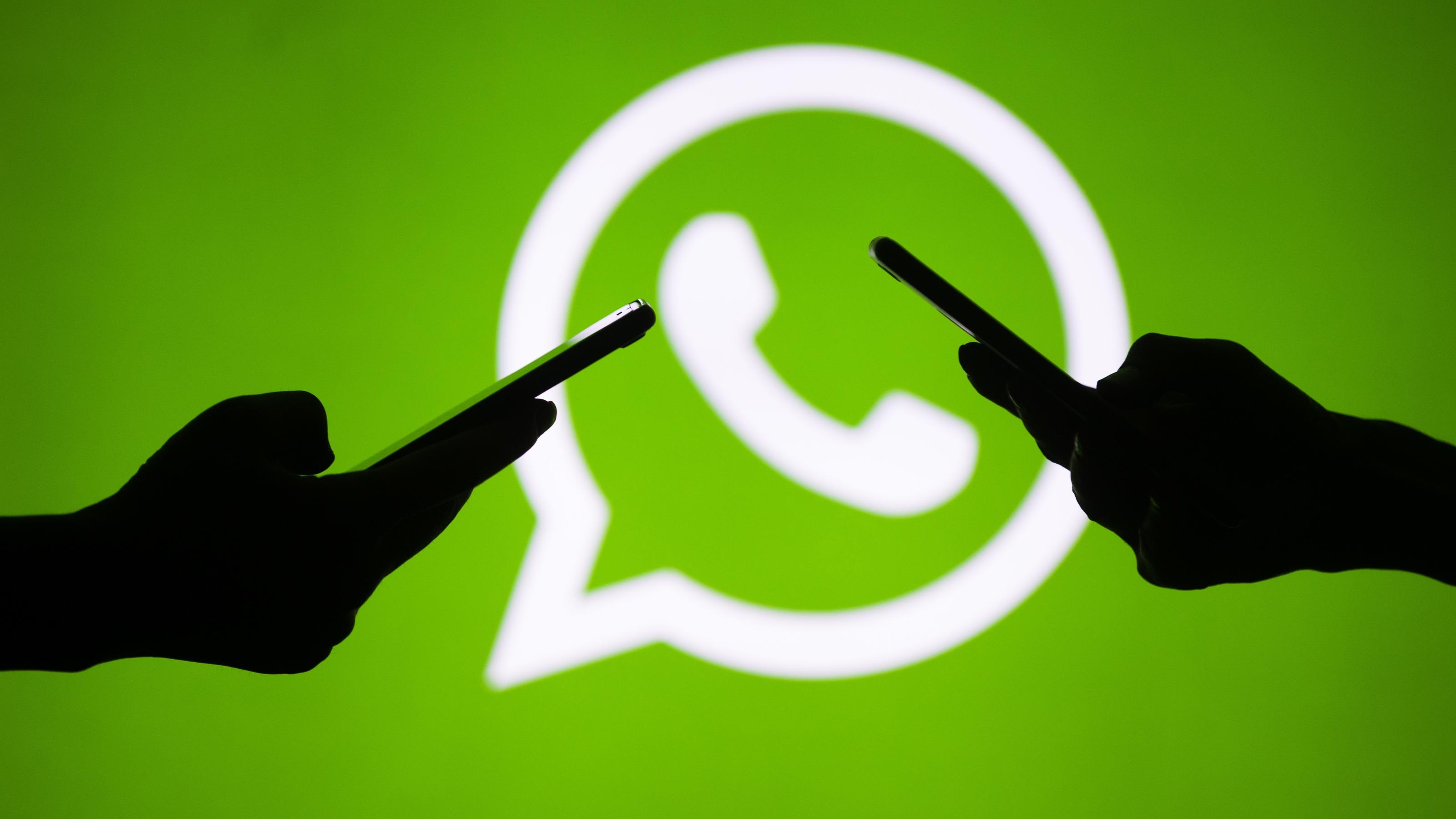 Whatsapp-Sticker-Funktion: Rechtsextreme verbreiten NS-Symbolik Hände mit Smartphones vor Whatsapp-Logik