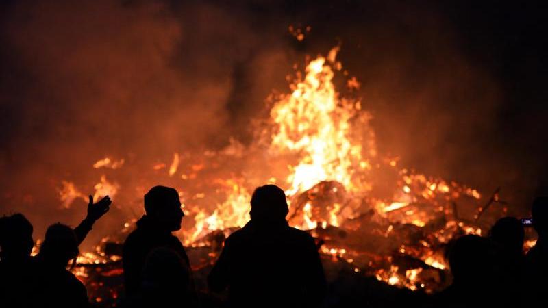 Kritik an Osterfeuern Menschen stehen an einem Osterfeuer