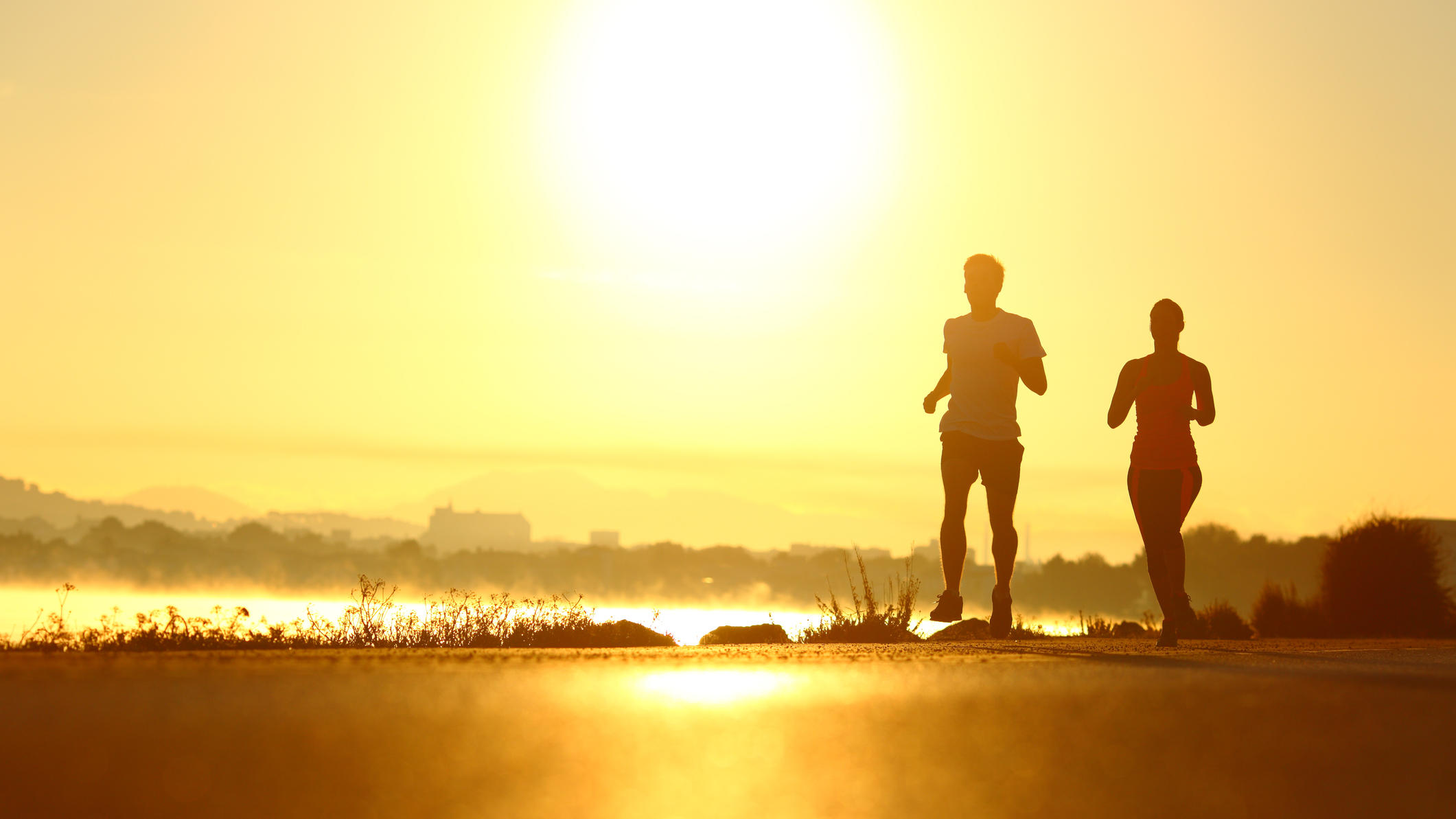 Forscher ermitteln die ideale Tageszeit zum Abnehmen Mann und Frau laufen im Sonnenaufgang