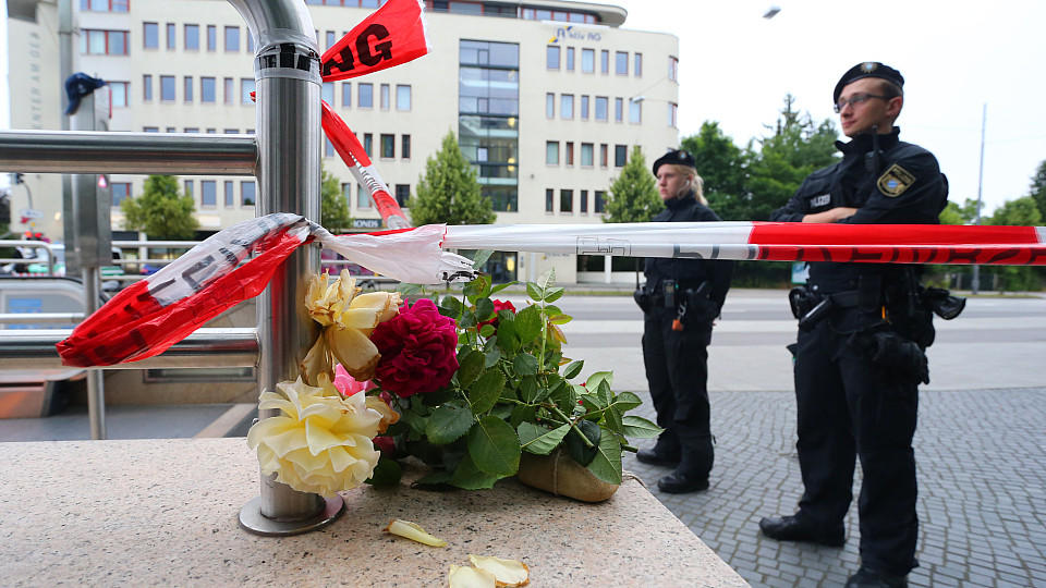 Verletzte bei Messerattacke in München - Tatverdächtiger festgenommen Blumen liegen am 23.07.2016 am Zugang zur U-Bahnstation Olympia-Einkaufszentrum in München (Bayern), den die Polizei nach einer Schießerei am Vortag abgesperrt hat. Die tödlichen Schüsse hat ein 18-jähriger Deutsch-Iraner abgegeben. Zehn Menschen sta