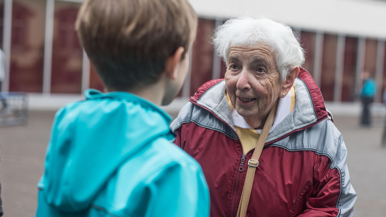 Zeitzeugin erzählt: Wie Kindertransporte den Nachwuchs vor den Nazis retteten Lee Edwards spricht auf dem Pausenhof des Heinrich von Gagern-Gymnasiums in Frankfurt mit einem Schüler.