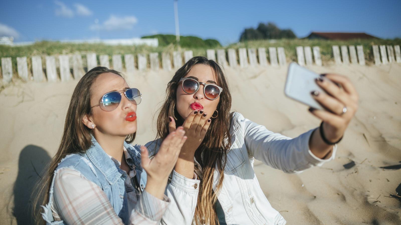 Das perfekte Urlaubs-Selfie: Mit diesen sechs Tricks sehen Sie toll aus! Zwei Frauen am Strand machen ein Selfie