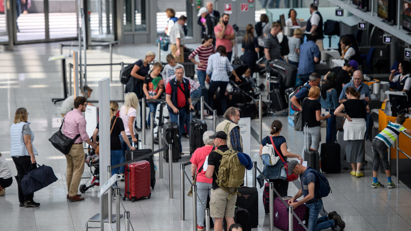 Neues Reiserecht! Das sollten Sie bei Ihrer nächsten Urlaubsbuchung beachten Reisende stehen an Check-In-Schaltern am Flughafen in München (Bayern). Zum Beginn der Pfingstferien in Bayern 02.06.2017 brechen zahlreiche Menschen in den Urlaub auf. Foto: Matthias Balk/dpa +++(c) dpa - Bildfunk+++