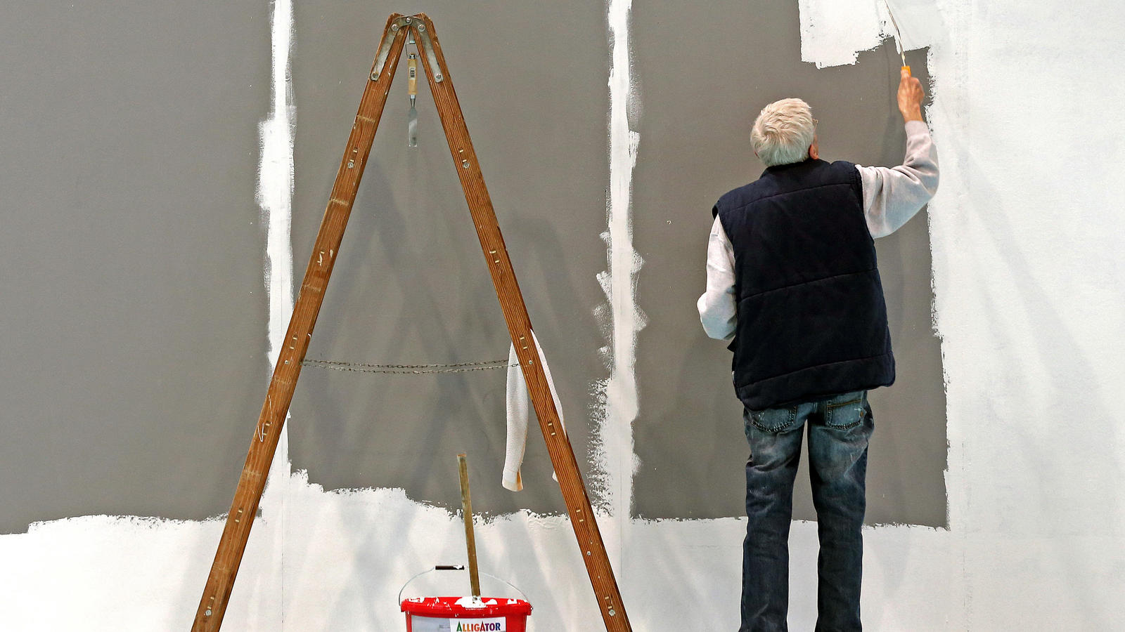Von wegen entspannter Lebensabend: Immer mehr Menschen arbeiten im Alter ARCHIV - Ein älterer Mann mit grauen Haaren streicht am 18.02.2014 auf der Leipziger Messe in Leipzig (Sachsen) eine Wand. Das Statistisches Bundesamt teilt am 12.07.2017 Zahlen zur Erwerbstätigkeit von älteren Menschen (65 bis 74 Jahre) für das Jahr