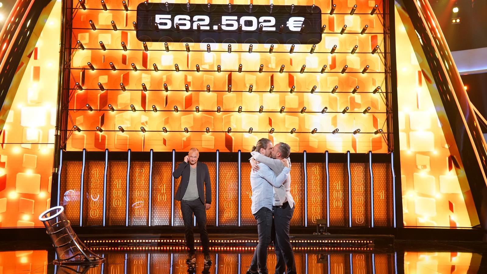 The Wall: Michael und Timur gewinnen 562.502 Euro Moderator Frank Buschmann (l.) mit dem Kandidaten-Ehepaar Timur (30, r.) und Michael (27) aus Köln, die sich über ihren Gewinn in Höhe von 562.502 Euro freuen.