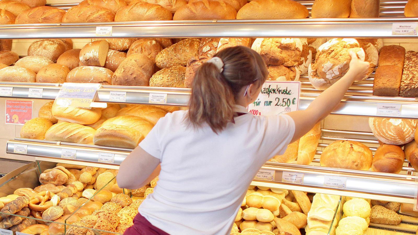 Ein Job allein reicht nicht zum Leben – immer mehr Menschen haben mehrere Arbeitgeber ARCHIV - Eine Verkäuferin greift am 14.03.2011 in einer Filiale einer traditionellen Bäckerei in Zwenkau (Landkreis Leipzig) nach einem Brot. (ZU dpa "Bäcker zwischen Pleite und Finanzinvestoren - Am Bahnhof läuft's" vom 20.09.2017) Foto: Jan Woitas/