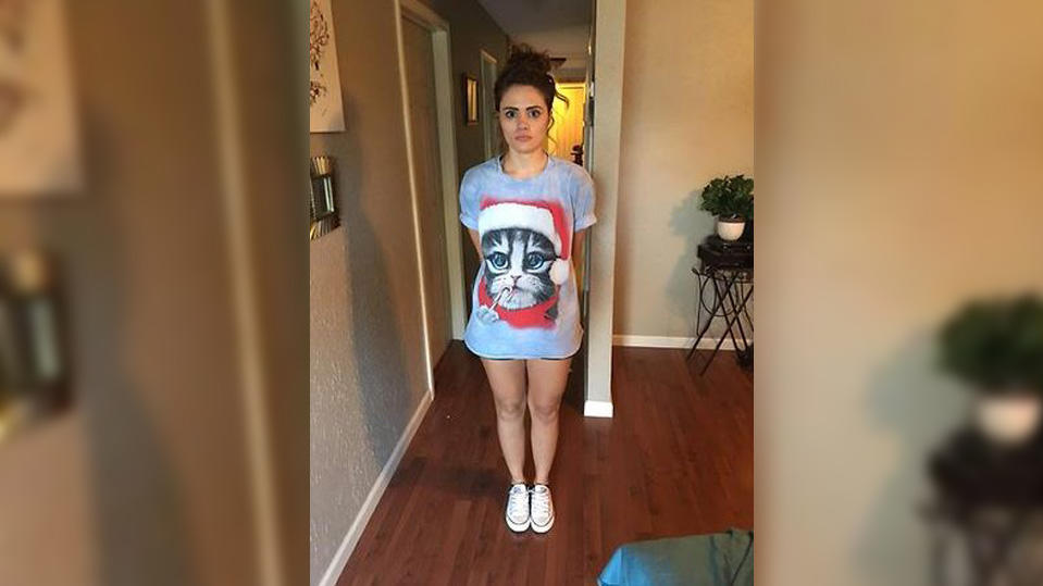 In die Falle gelockt: US-Polizei verhaftet Lehrerin bei Sex-Date mit Schüler (16) Eine junge Frau steht in einem großen, grauen T-Shirt mit weihnachtlichem Katzenmotiv und kurzer Hose im Flur einer Wohnung.