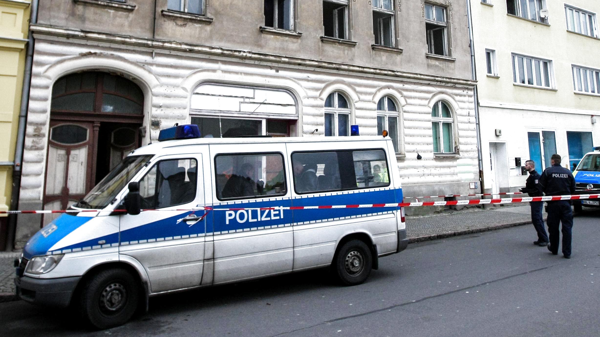 Brandenburg: Zwei Leichen in brennender Wohnung entdeckt Die Polizei steht vor einem Mehrfamilienhaus in Rathenow (Brandenburg).