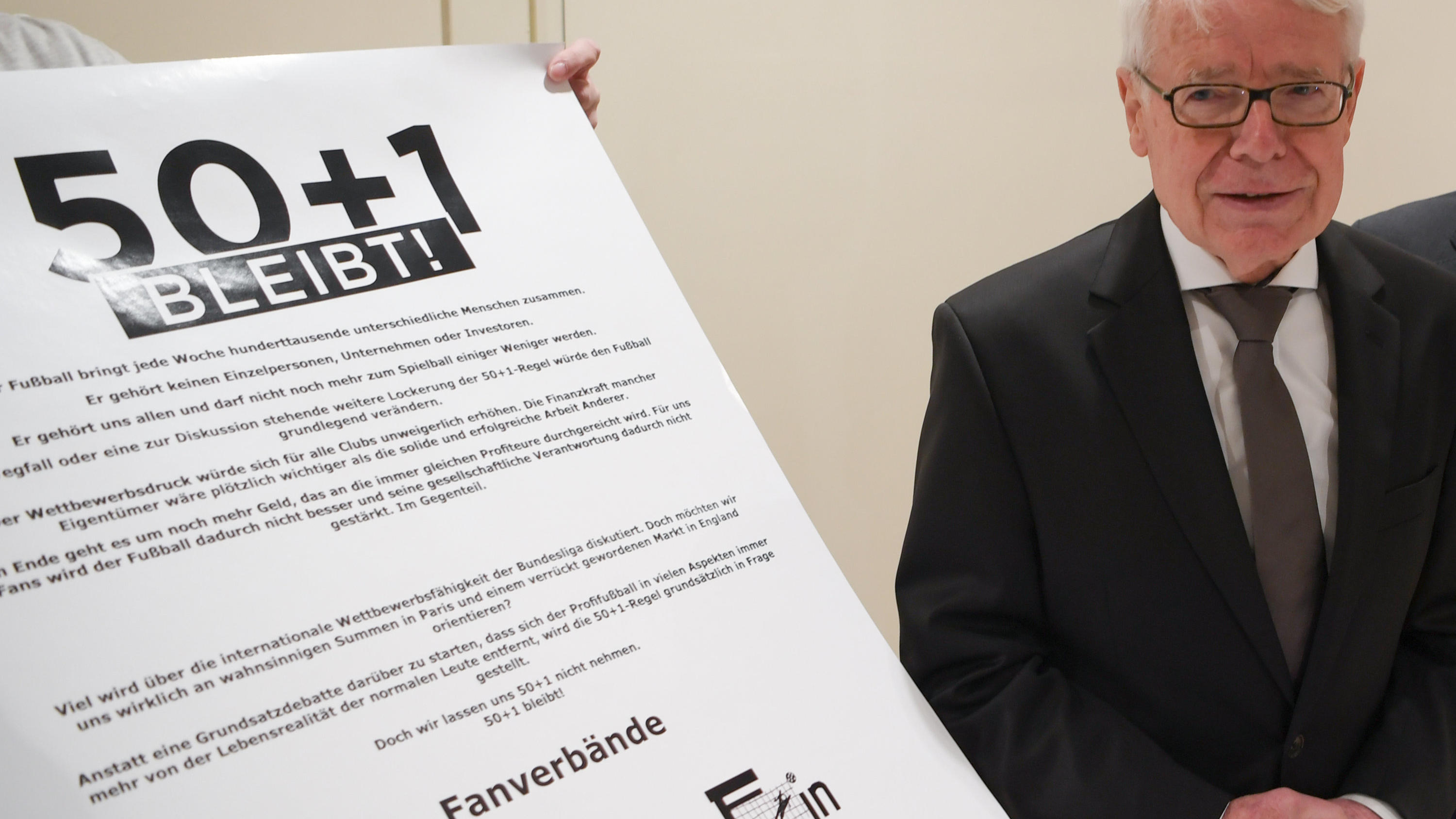Bundesliga: Umstrittene 50+1-Regel und Videobeweis bleiben 22.03.2018, Hessen, Frankfurt am Main: Reinhard Rauball, Präsident der DFL, erhält am Rande der Mitgliederversammlung der Deutschen Fußball Liga (DFL) am Frankfurter Flughafen eine Erklärung der Fans für den Erhalt der 50+1-Regel überreicht. Die Vert