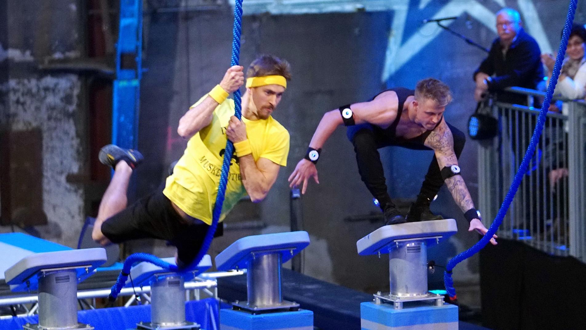 Team Ninja Warrior Germany: So läuft die Show ab Vorrunde: John-Edouard Ehinger (l.), Kapitän des Teams "Die 3 Muske(l)tiere" tritt gegen Kevin Kapelski, Kapitän des Teams "Spotlight" an.
