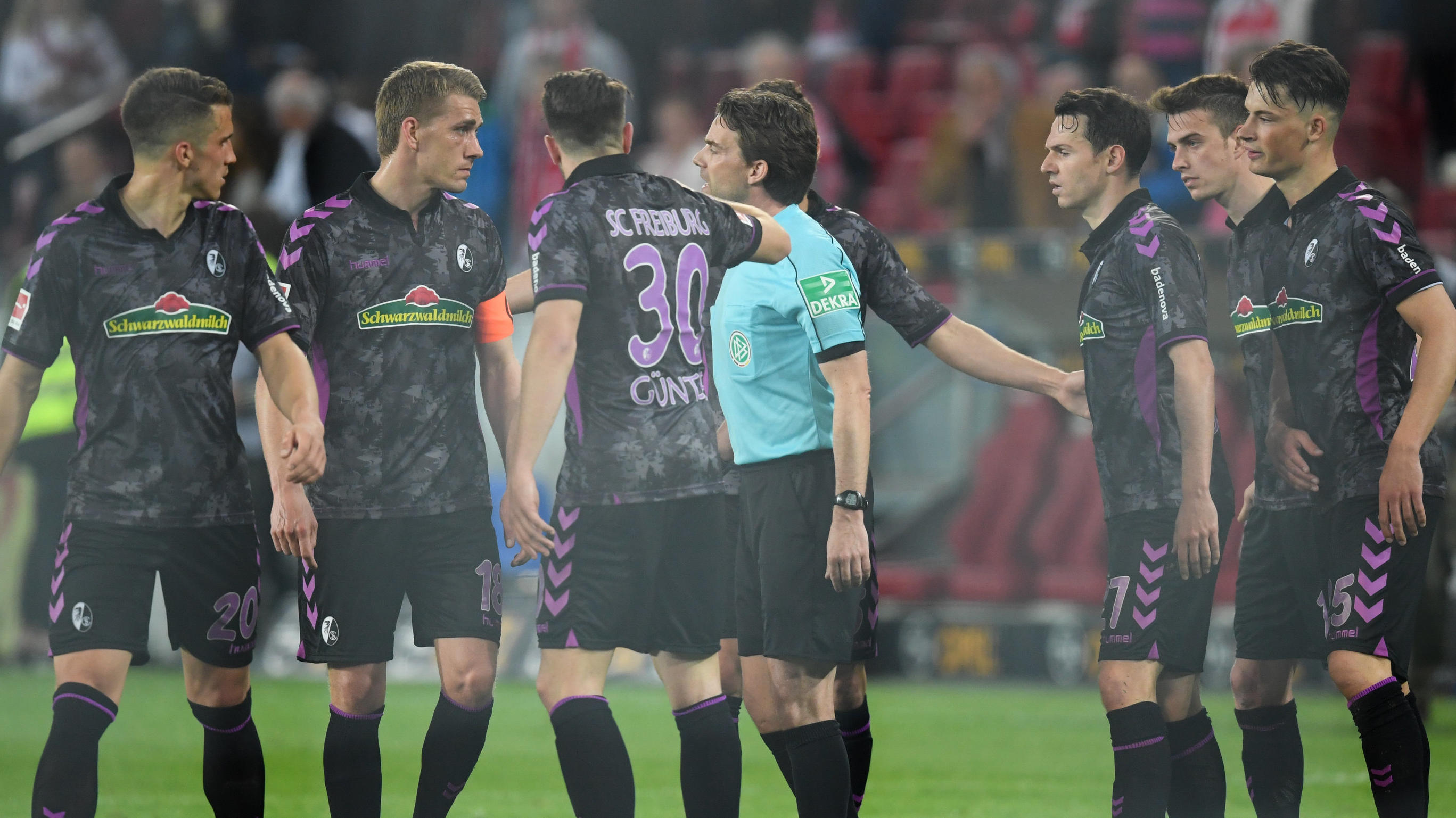 Kuriosum in Mainz: Videobeweis führt zu Elfmeter in der 'Pause' 16.04.2018, Rheinland-Pfalz, Mainz: Fußball, Bundesliga, 30. Spieltag: 1. FSV Mainz 05 - SC Freiburg in der Opel Arena. Schiedsrichter Guido Winkmann (M) spricht nach der Entscheidung des Videoschiedsrichters mit den Freiburger Spielern. Foto: Arne D