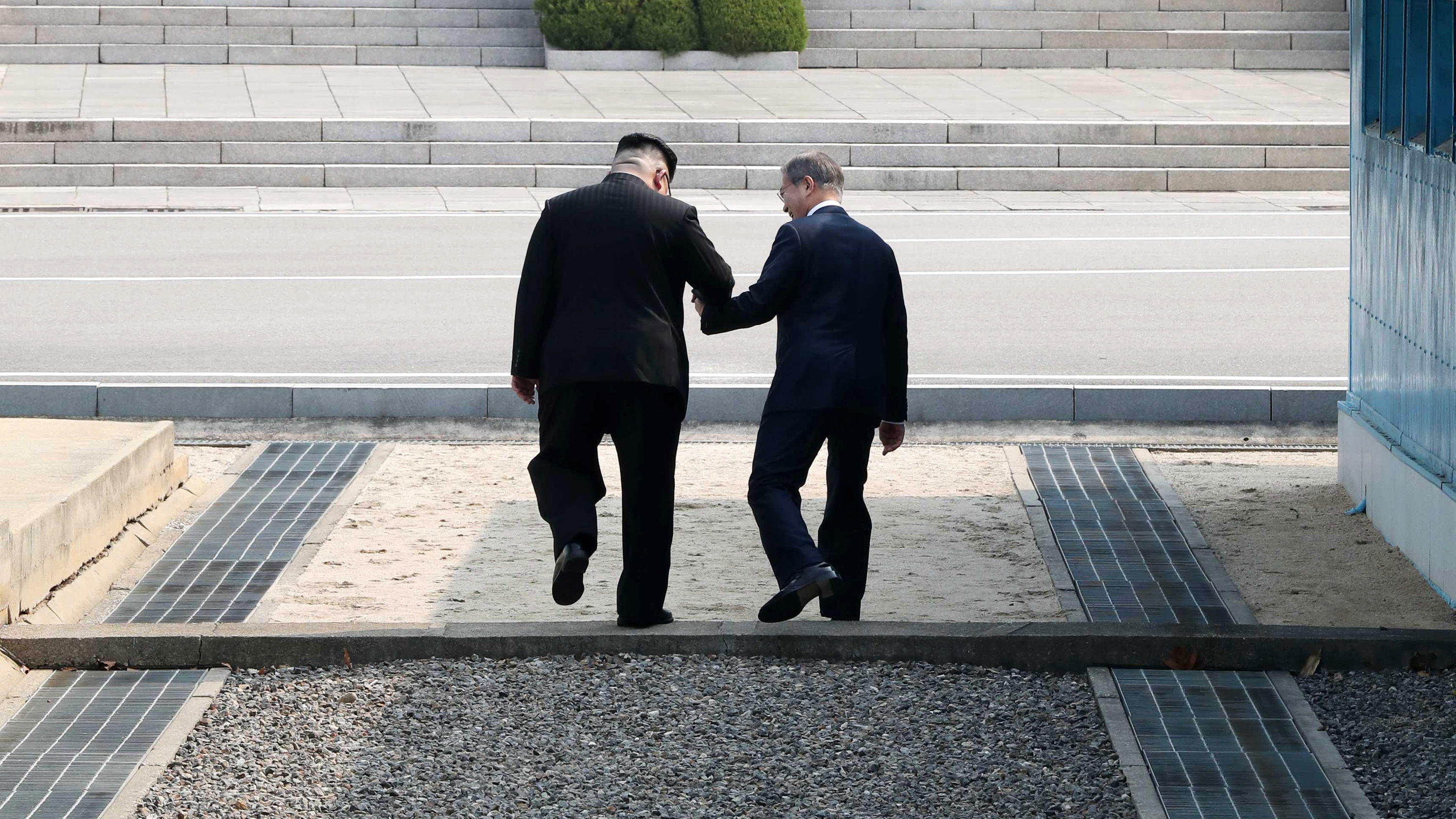 Trump kündigt Treffen mit Kim Jong Un in den "nächsten drei, vier Wochen" an dpatopbilder - 27.04.2018, Südkorea, Panmunjom: Kim Jong Un (l), Machthaber von Nordkorea, und Moon Jae In, Präsident von Südkorea, gehen Hand in Hand über die Betonschwelle, die die Grenze zwischen ihren Ländern markiert nach Nordkorea. Als erster n