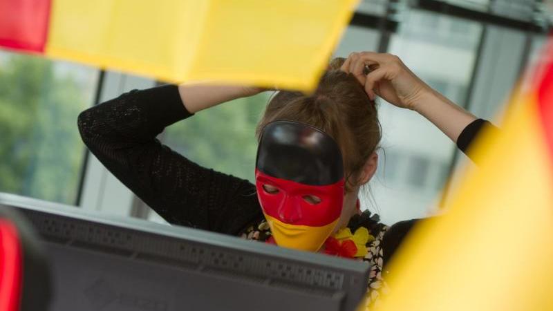 Überlebenstipps für WM-Muffel Mensch mit Deutschland-Maske