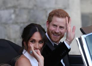 Winkend fahren Prinz Harry und Meghan in einem blauglänzenden Cabrio durch ... weiterlesen