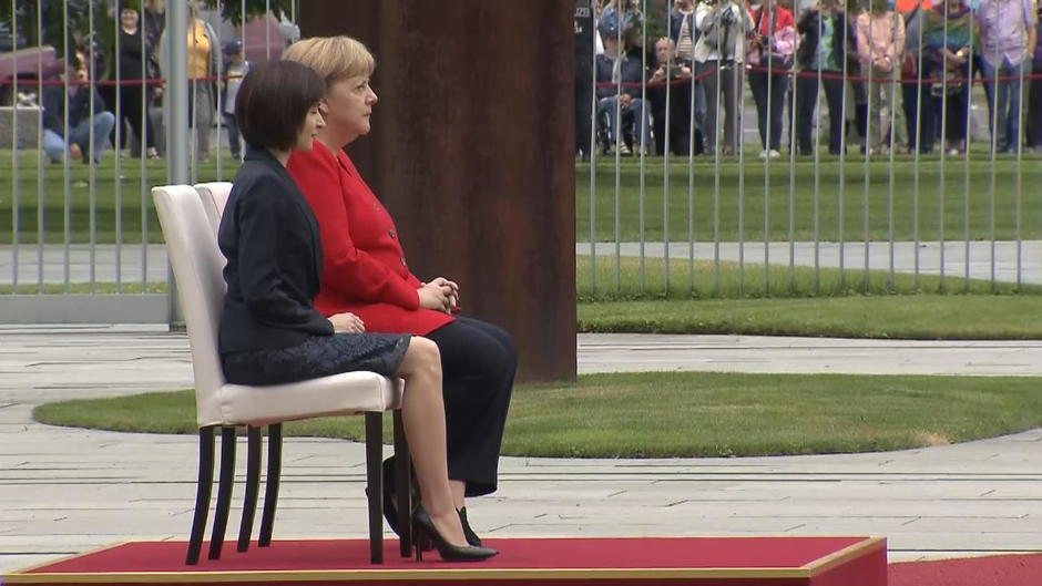 Merkel sitzt erneut bei Hymne, zittert aber nicht Merkel sitzt erneut bei Hymne, zittert aber nicht