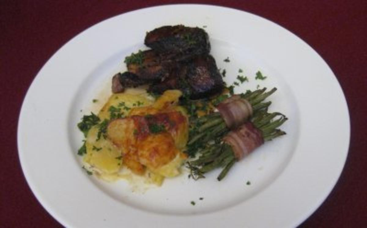 Geschmorte Kalbsrippchen mit Kartoffelgratin und grünen Bohnen im Speckmantel