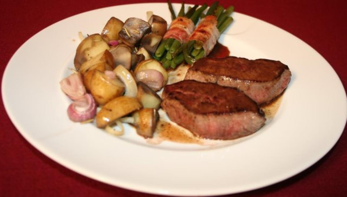 Hirschsteak Schweizer Art, dazu Bohnen im Speckmantel und Rosmarinkartoffeln