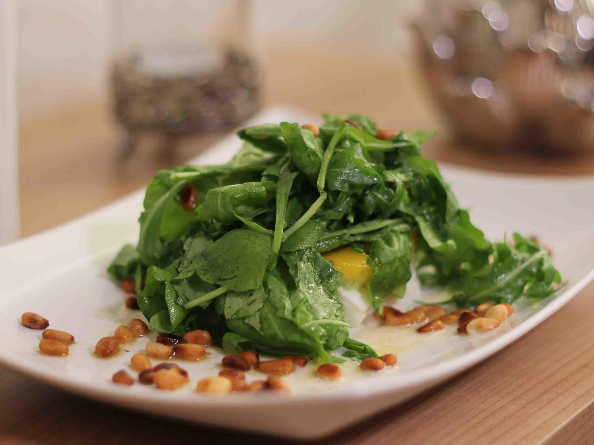 Fruchtiger Salat aus Rucola, Mango, Avocado und Mozzarella garniert mit Pinienkernen
