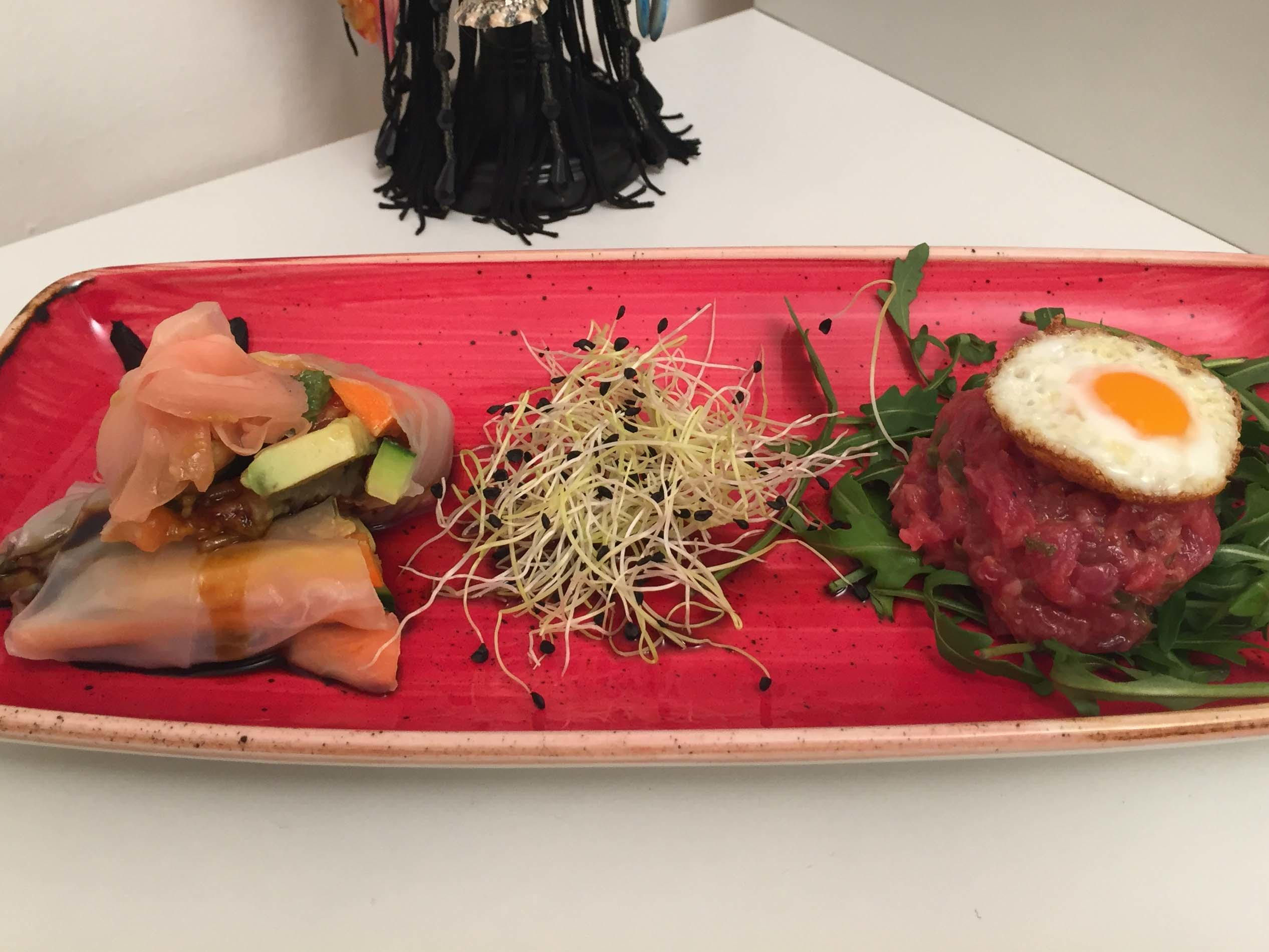 Vietnamesische Frühlingsrollen auf Wakame treffen auf Beef Tartar mit Wachtelspiegelei