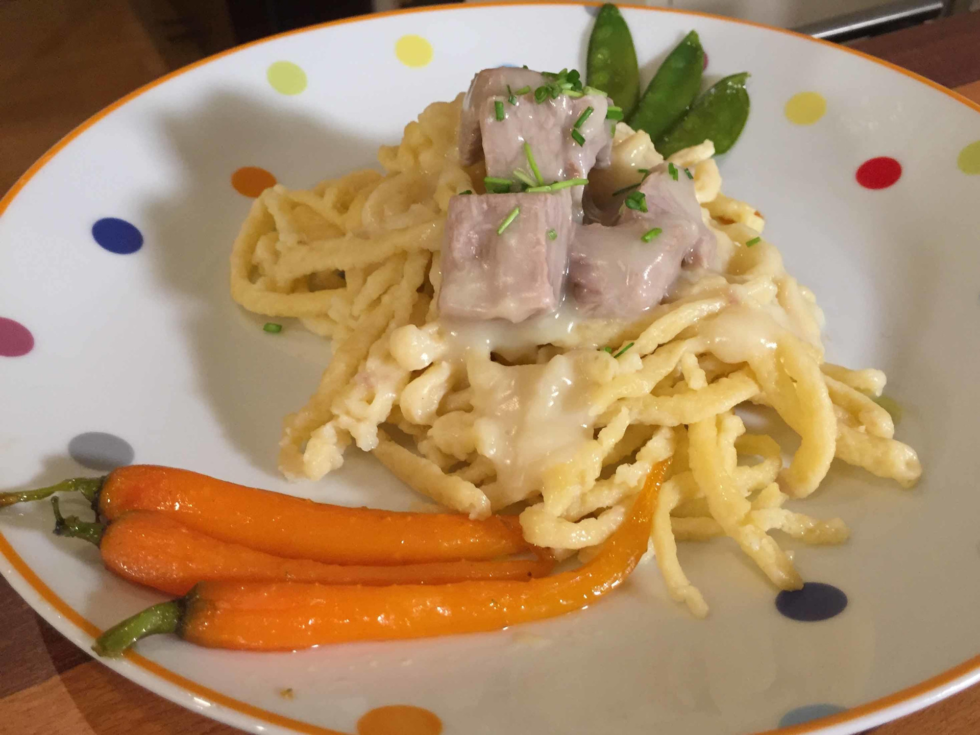 Eingemachtes Kalbsfleisch mit Spätzle, karamellisierten Babykarotten und Zuckerschoten