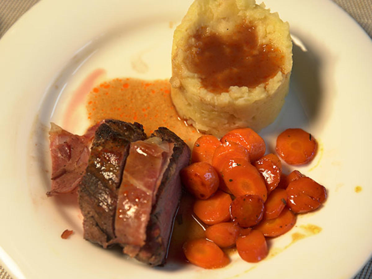 Rosa gegartes Kalbsfilet im Speckmantel an Rotweinsauce