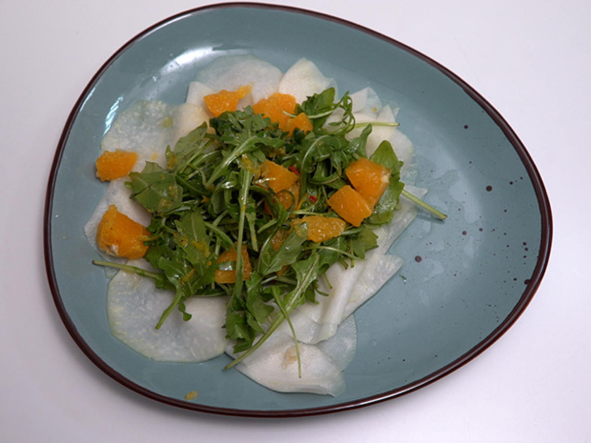 Carpaccio von dem Kohlrabi in Symbiose mit zitrischer Vinaigrette, Rucola und Orangenfile