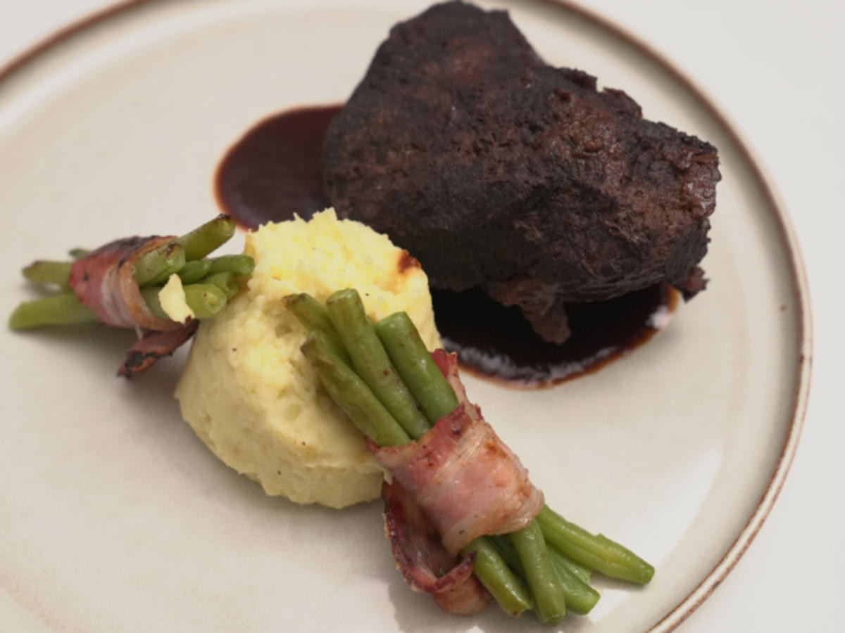 Ochsenbäckchen mit Kartoffelstampf und Bohnen im Speckmantel