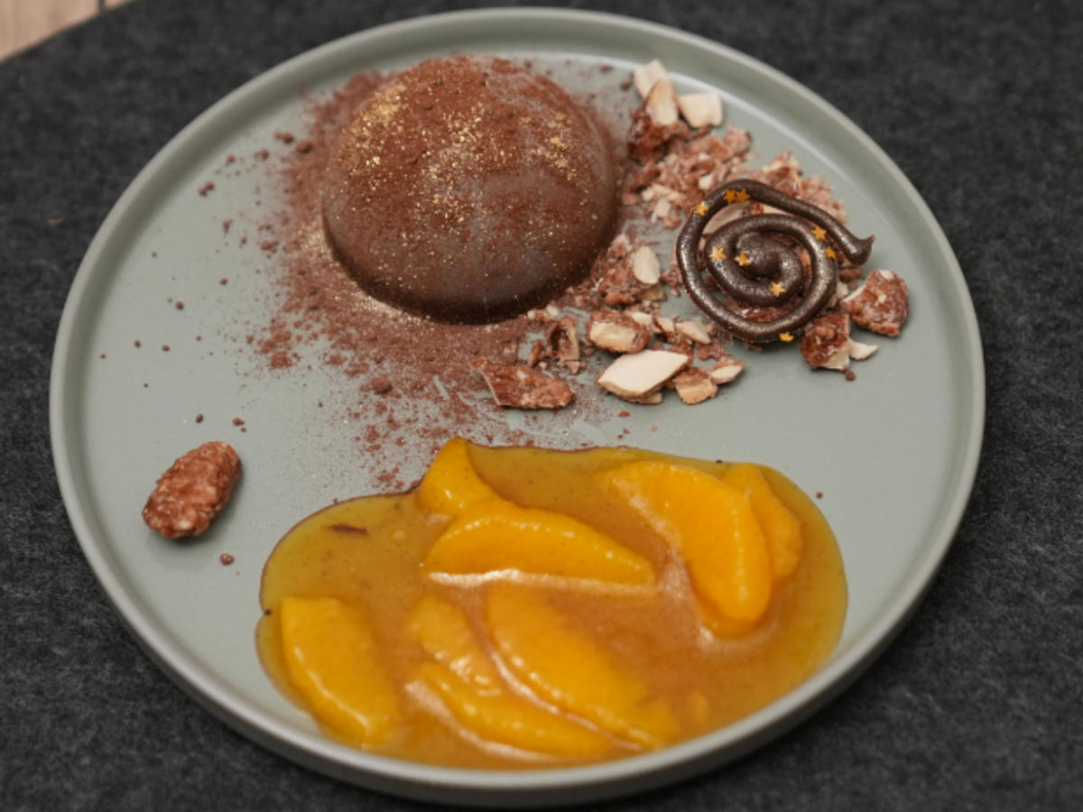Orangenlikörparfait in Schokohalbkugel mit Gewürzorangen und gebrannten Mandeln