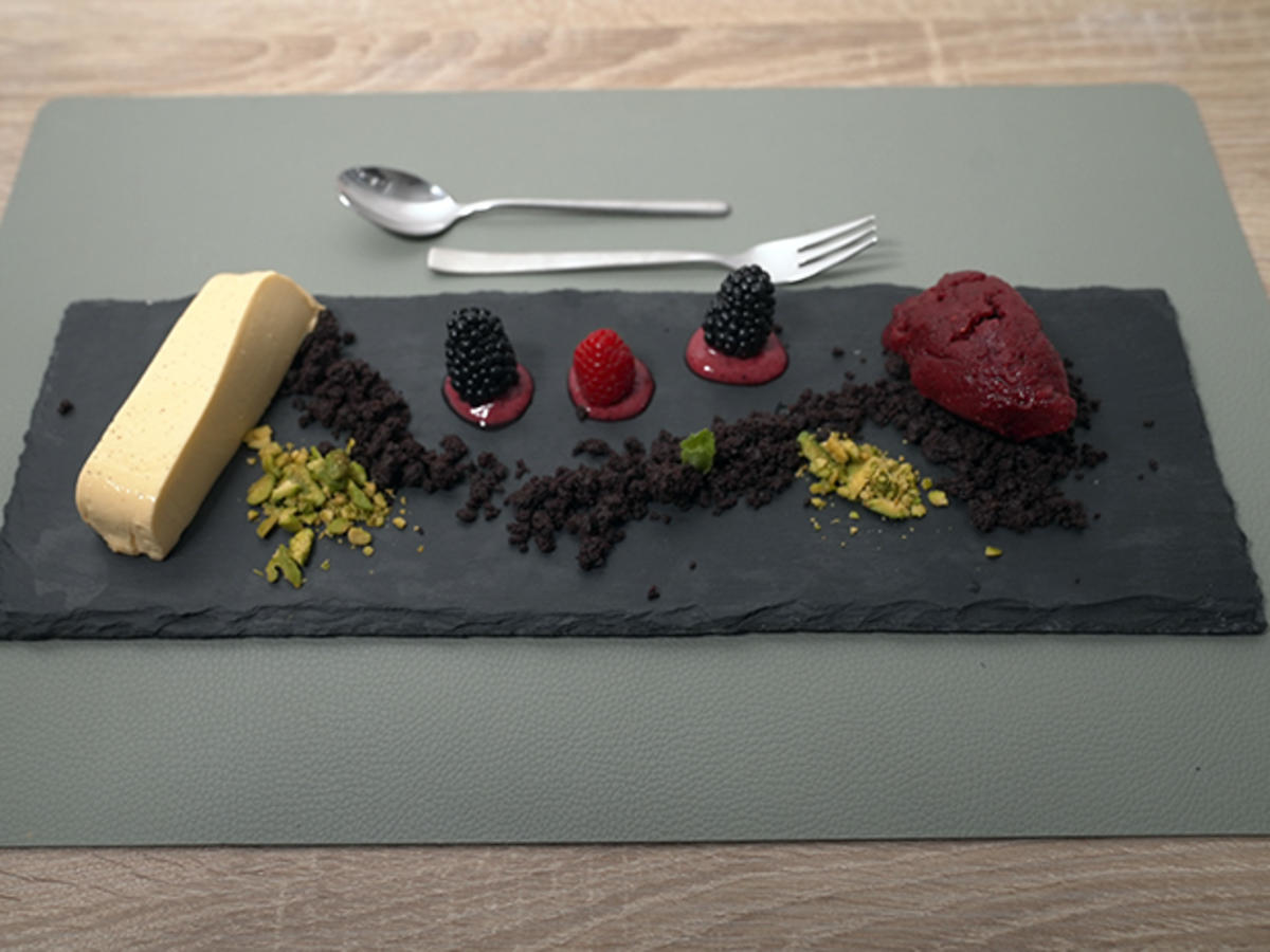 Rosmarin-Vanille-Creme mit Schoko-Crumble, geeisten Beeren und Pistazie